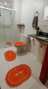 uma casa de banho com um WC laranja e um chuveiro em Apartamento Beira Rio no Condomínio Brisas do Lago em Paulo Afonso