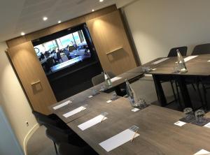a conference room with tables and chairs and a television at Logis Hôtel Les Mouettes Restaurant ERIN - Larmor Plage, Proche de LORIENT in Larmor-Plage