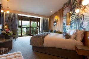 um quarto de hotel com uma cama grande e uma varanda em Wineport Lodge em Glasson