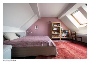 ein Schlafzimmer im Dachgeschoss mit einem Bett und einem Bücherregal in der Unterkunft City, Lake and Luxury in Zürich