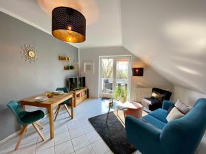 a living room with blue chairs and a table at Ferienappartements Mund - Adults only in Gothen