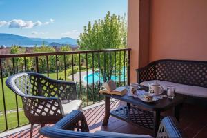 a balcony with a table and chairs and a view of a pool at Residence Edera 18 by Wonderful Italy in Polpenazze del Garda
