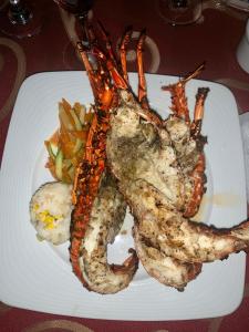 a plate of food with lobster and vegetables on a table at Paradise Huatulco Condo TANGOLUNDA BEACH in Tangolunda