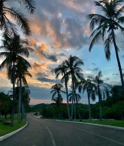 a street with palm trees on the side of a road at Paradise Huatulco Condo TANGOLUNDA BEACH in Tangolunda