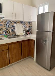 a kitchen with a stainless steel refrigerator and a sink at Paradise Huatulco Condo TANGOLUNDA BEACH in Tangolunda
