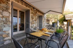 a black table and chairs on a patio at Casa di campagna Rosina con piscina e vista lago in Gravedona