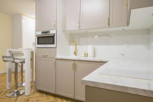 una cocina blanca con armarios blancos y fregadero en Central Apartments Goleniow Luxury en Gollnow