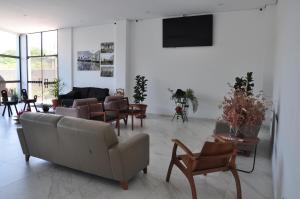 a living room with a couch and chairs at Hotel Peregrinos in Aparecida