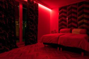 a red bedroom with a bed and a red light at Central Apartments Goleniow Luxury in Goleniów