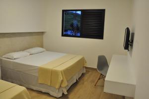 a bedroom with two beds and a window at Hotel Peregrinos in Aparecida