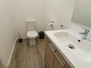 a bathroom with a white sink and a toilet at Canyelles BBQ Apartment in Lloret de Mar