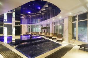 a hotel lobby with a pool and chairs at SPA Resort HeRICH in Bukovel +31 photos