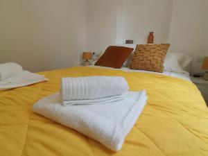 a yellow bed with towels on top of it at Canyelles BBQ Apartment in Lloret de Mar