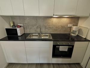 a small kitchen with a sink and a microwave at Canyelles BBQ Apartment in Lloret de Mar