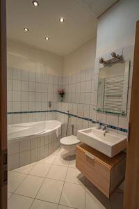 a bathroom with a sink and a tub and a toilet at Ruterra Apartment Charles Bridge in Prague