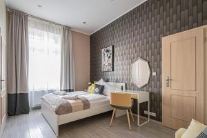 - une chambre avec un lit, un bureau et un miroir dans l'établissement Ruterra Apartment Charles Bridge, à Prague