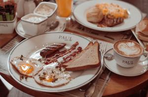 - une table avec des assiettes de produits pour le petit-déjeuner et une tasse de café dans l'établissement Luxury Duplex Suites - City Center, à Tbilissi