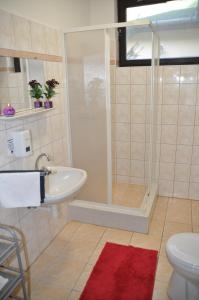 een badkamer met een douche, een wastafel en een toilet bij Fűz Apartman in Balatonfůzfő