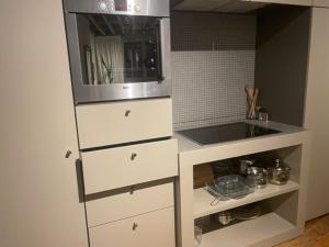 cocina con armarios blancos y microondas en Duplex dernier étage avec terasse à deux pas de la grand place en Bruselas