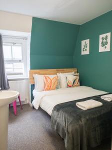 a bedroom with a large bed with a green wall at Smart Hyde Park Inn in London