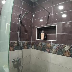 a bathroom with a shower with a glass door at Апартамент "Рая" in Dobrich