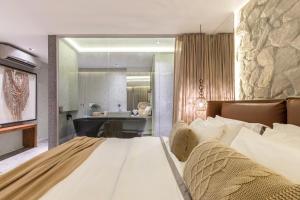 a bedroom with a large bed and a bathroom at Villas Supreme Hotel in Maceió