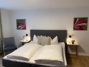 Un dormitorio con una cama con sábanas blancas y una silla azul. en Hotel Ostermann en Treis-Karden