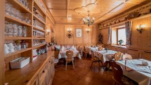 - un restaurant avec des tables et des chaises dans une salle dotée de murs en bois dans l'établissement Gasthof Neuwirt, à Ellbögen