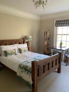 um quarto com uma grande cama de madeira e um lustre em Gallows Hill em Scarborough