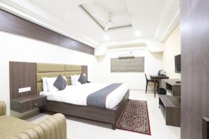 a hotel room with a bed and a desk at Alba Premier, Ahmedabad in Ahmedabad