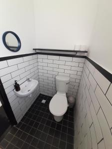 a bathroom with a toilet and a sink at Cozy room in the Heart of Simon's Town in Cape Town