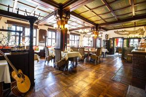 una habitación con mesas y una guitarra en un restaurante en Hotel Rüdesheimer Hof - Superior, en Rüdesheim am Rhein