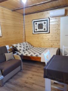 a small room with a bed and a couch at Domek SERCE KRYNICY in Krynica Morska