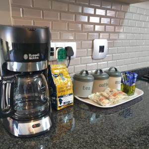 - une cafetière sur un comptoir à côté d'une assiette de nourriture dans l'établissement @Lloyds, à Ermelo