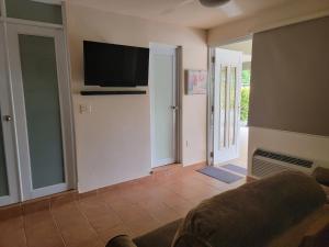 a living room with a couch and a flat screen tv at Private Beachfront House in Cabo Rojo