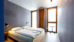 a bedroom with a bed and a large window at Bern Youth Hostel in Bern