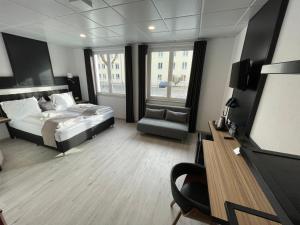 金茨堡的住宿－Yebs Hotel，一间卧室配有一张床、一把椅子和电视。
