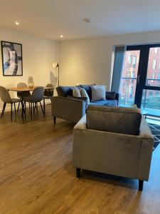 a living room with a couch and a table with chairs at Icona - Stylish 2 bed apartment in York