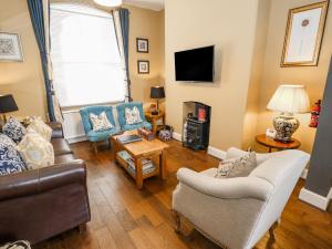 a living room with a couch and chairs and a tv at The Townhouse in York