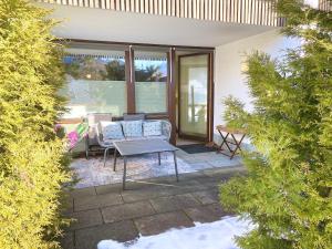 a patio with a table and chairs in a yard at Ferienwohnung Kirchbichl am Schliersee mit Terrasse in Schliersee