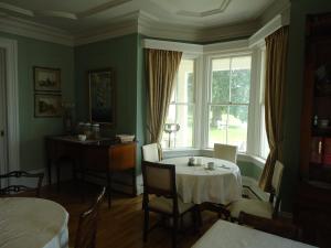 comedor con mesa y ventana en Governor's Mansion Inn, en Miramichi