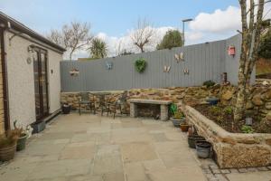 a patio with a table and chairs and a fence at Pippas place in Penzance
