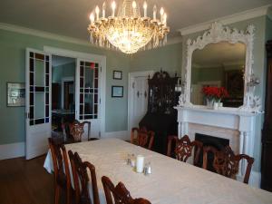 comedor con mesa y lámpara de araña en Governor's Mansion Inn, en Miramichi