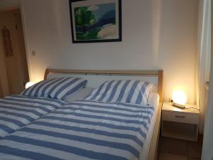 - 2 lits avec des draps rayés bleus et blancs dans une chambre dans l'établissement Darßer Weg 32a "Kormoran" Wohnung 16, à Zingst