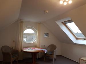 une chambre avec une table, deux chaises et une fenêtre dans l'établissement Darßer Weg 32a "Kormoran" Wohnung 16, à Zingst