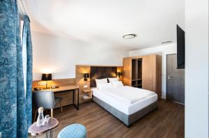 um quarto de hotel com uma cama e uma secretária em Schnitzers Dahoam - Hundefreundlich em Bad Wiessee