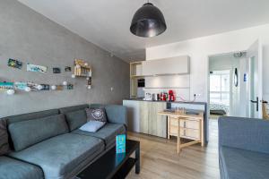 a living room with a couch and a kitchen at À 50m de la Grande Plage, appartement pour 4 in Saint-Gilles-Croix-de-Vie +25 photos
