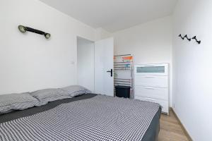 a white bedroom with a bed and a dresser at À 50m de la Grande Plage, appartement pour 4 in Saint-Gilles-Croix-de-Vie
