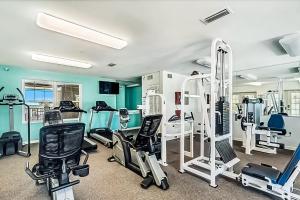 a gym with treadmills and machines in a room at Grande Caribbean in Orange Beach