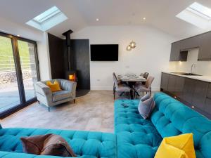 a living room with a blue couch and a table at Limestone in Ulverston